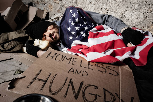 istock Homeless man sleeping outsie under American flag 1094446900