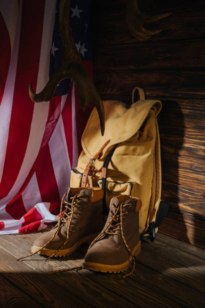 istock trekking boots, backpack, horns and american flag on wooden surface 1094448700