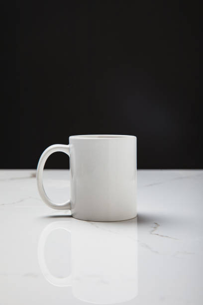 istock close-up view of white cup reflected on white surface on black 1094448756