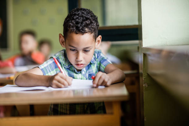 istock African American schoolboy writing a dictation during a class in elementary school. 1094448930