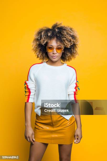 Confident Beautiful Afro Young Woman Against Yellow Background Stock Photo - Download Image Now