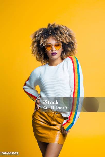 Confident Beautiful Afro Young Woman Against Yellow Background Stock Photo - Download Image Now