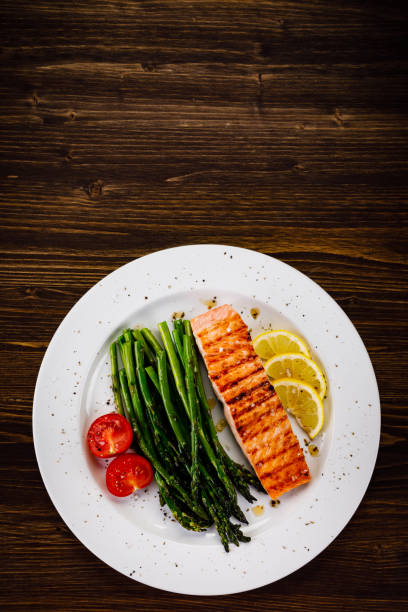 istock Grilled salmon with asparagus and arugula on wooden table 1094449348