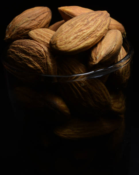 istock Almond in a small glass with dark background 1094449448