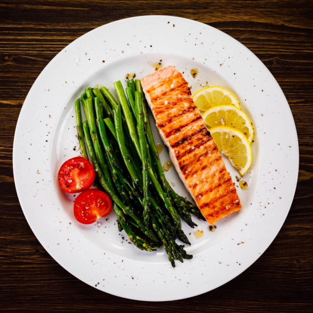 istock Grilled salmon with asparagus and arugula on wooden table 1094449532