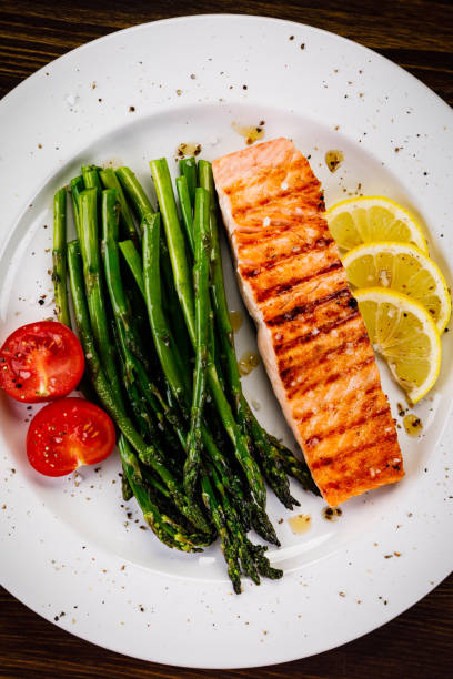 istock Grilled salmon with asparagus and arugula on wooden table 1094449712