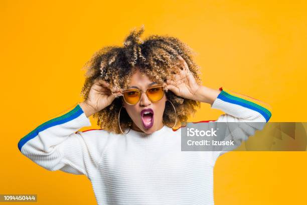 Funky Afro Girl Against Yellow Background Stock Photo - Download Image Now - Afro Hairstyle, Eyeglasses, Yellow Background