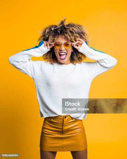 Funky Afro Young Woman Against Yellow Background Stock Photo - Download Image Now - Colored Background, Laughing, Adult