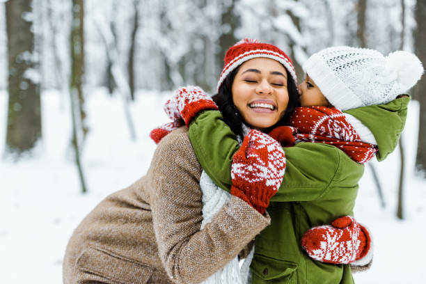cute african american daughter hugging mother in winter forest cute african american daughter hugging mother in winter forest children in winter stock pictures, royalty-free photos & images