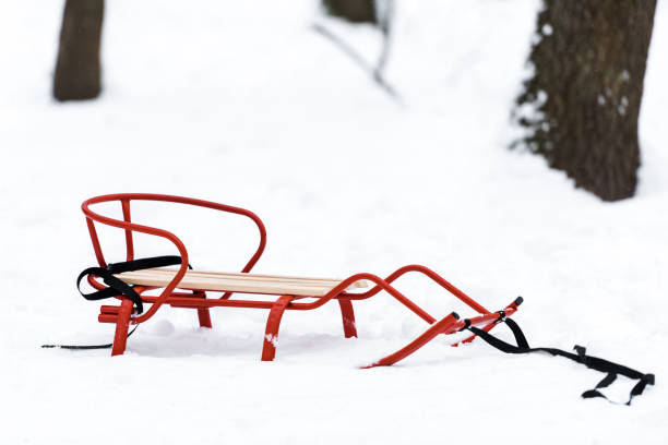 istock red metal sledge on snow with trees at background in winter 1094453726