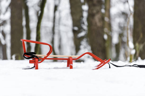 istock red sledge on snow with trees at background 1094453780