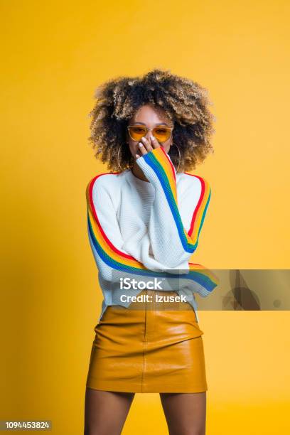 Surprised Afro Girl Standing Against Yellow Background Stock Photo - Download Image Now