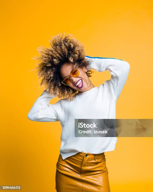 Excited Afro Young Woman Dancing Against Yellow Background Stock Photo - Download Image Now
