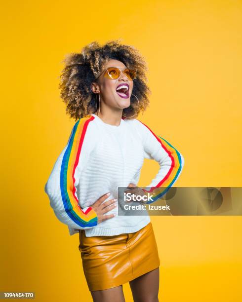 Excited Afro Girl Standing Against Yellow Background Stock Photo - Download Image Now