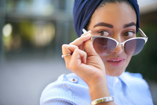 Cropped shot of an attractive young woman in glasses standing outside the mall