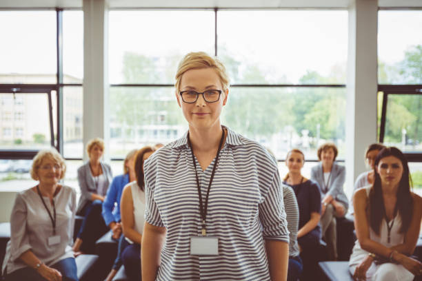 istock Confident female speaker with audience in background 1094457544