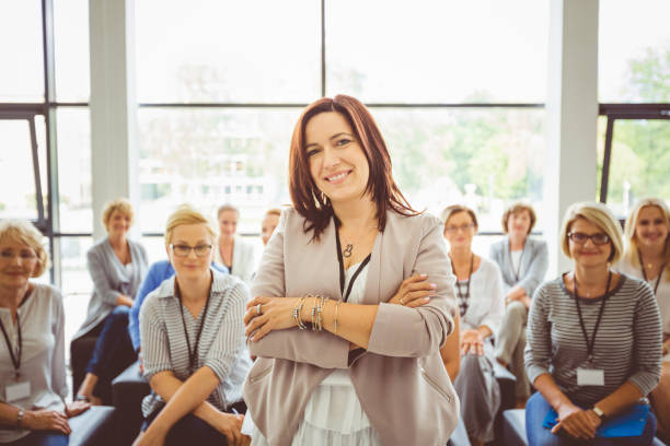 istock Female motivational speaker with audience at back 1094458116