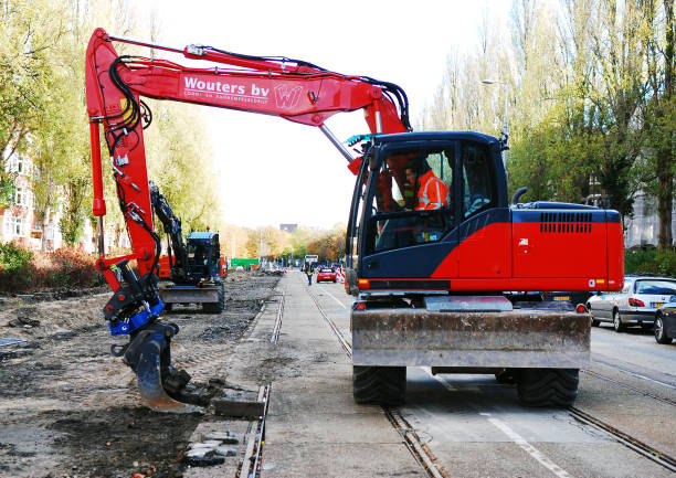 Crane operator using a mediun size crane doing reparation  work in the Tram lines on the streets of Amsterdam.