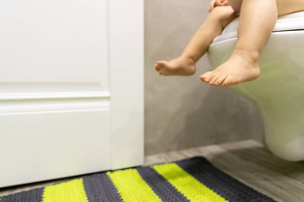 Baby Feet on the Toilet. Children's Concept. Restroom Child Sitting on the Toilet. Copy Space. Background diarrhea photos stock pictures, royalty-free photos & images