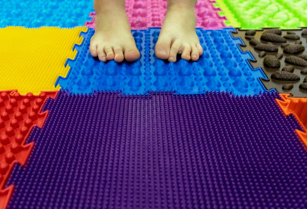 de voeten van de baby op een speciale orthopedische tapijt. achtergrond - neurology child stockfoto's en -beelden