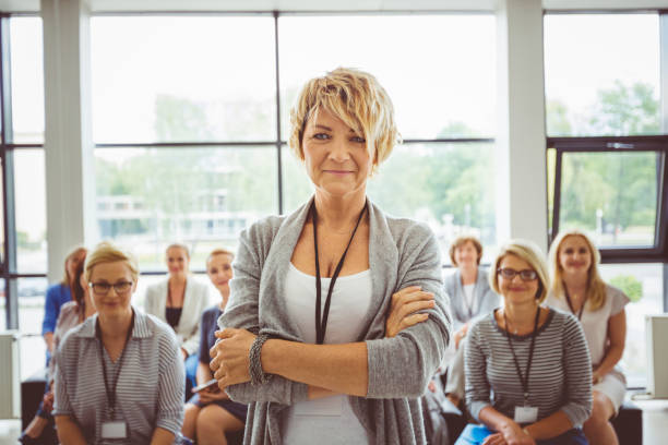 istock Mature female speaker with audience at back 1094461974