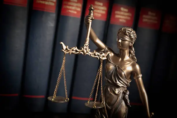 Photo of Statue of justice on books background
