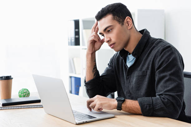 istock serious concentrated young businessman working with laptop in office 1094462906