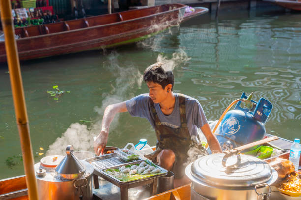 торговцы готовят еду для продажи туристам - damnoen saduak floating market asia asian ethnicity asian culture стоковые фото и изображения