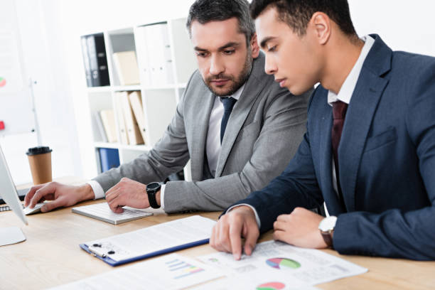 istock two concentrated business colleagues working with papers and desktop computer in office 1094466510