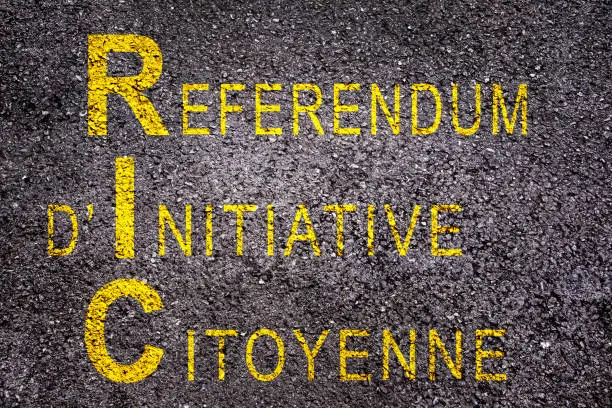 Photo of Word RIC (meaning referendum at citizen's initiative) on asphalt background