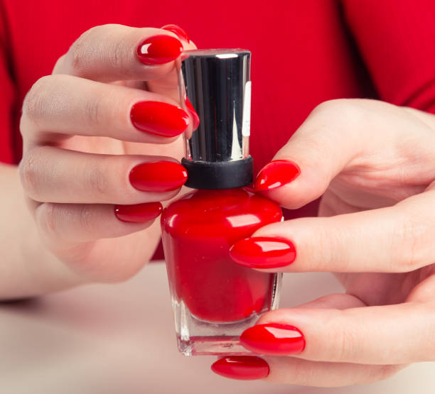 istock Female hand with red nail polish bottle 1094469326