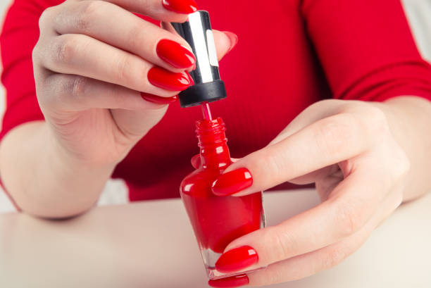 istock Female hand with red nail polish bottle 1094469330
