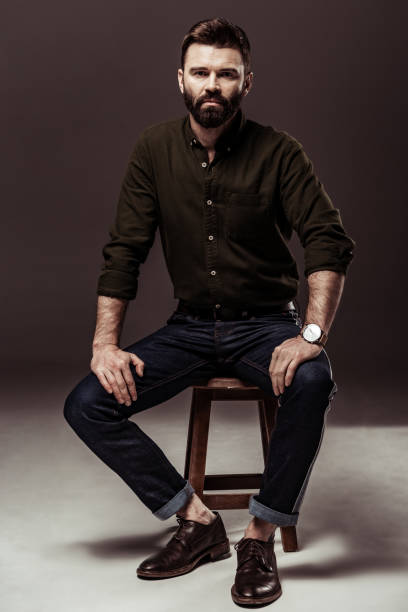 istock handsome bearded man looking at camera on brown background 1094470212