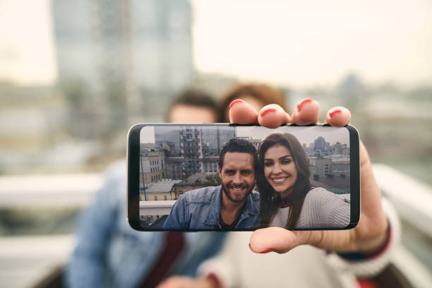 istock Nice smiling couple is doing photo by smartphone 1094470338