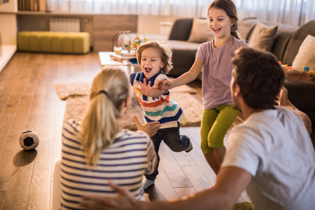 istock Joyful siblings having fun while running into their parent's hug at home. 1094471522