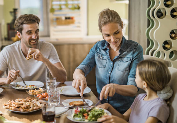 istock Young happy family enjoying during lunch time at dining table. 1094473198
