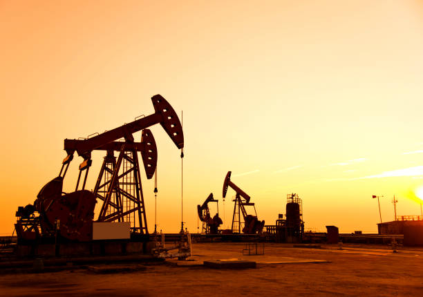 istock Oil pumps and rig at sunset 1094476344