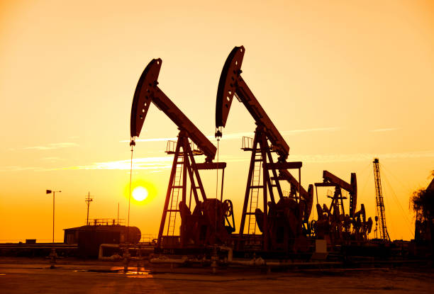 istock Oil pumps and rig at sunset 1094476376