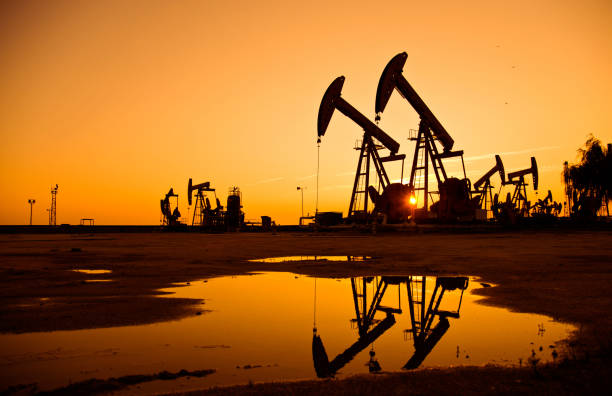 istock Oil pumps and rig at sunset 1094476440