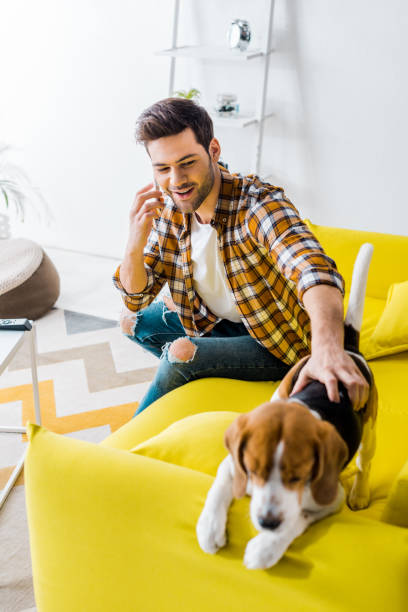istock happy young man talking on smartphone and looking at dog 1094476832