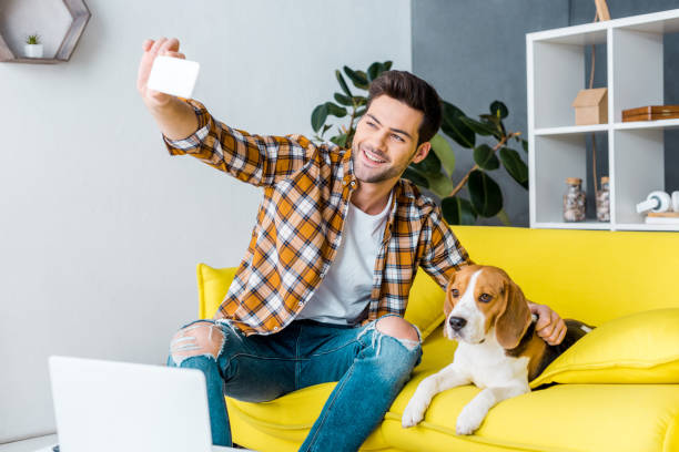 istock handsome smiling man taking selfie with beagle dog 1094476834