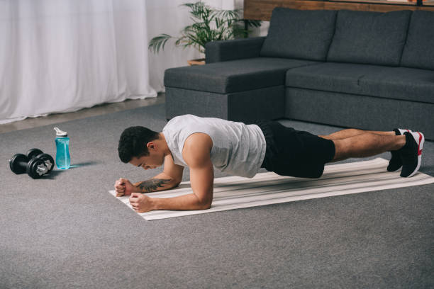 istock bi-racial athlete doing plank exercise on  fitness mat 1094479346