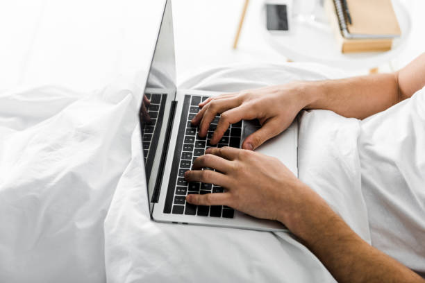 istock partial view of man using laptop in bed 1094483270
