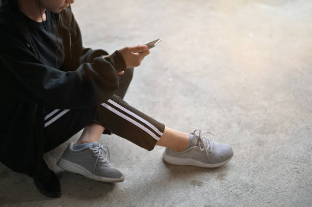 istock Runner woman using a mobile phone with ear phone pre-running on floor in home. 1094484232