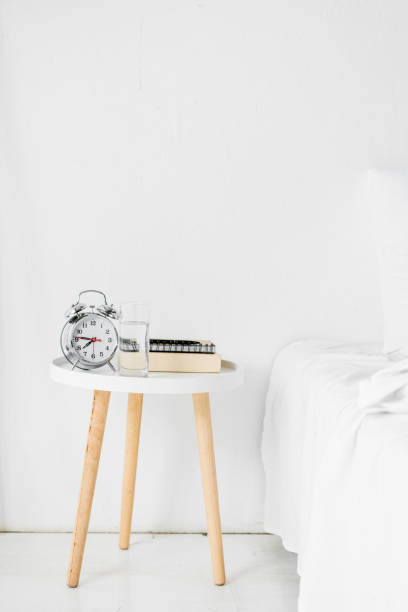 istock alarm clock and books on table near bed 1094488450