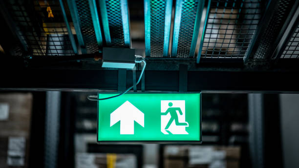 Green emergency exit sign or fire exit sign showing the way to escape with arrow symbol.