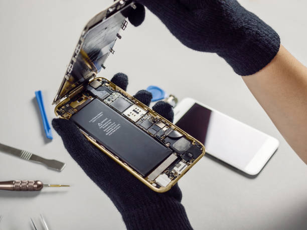 techniker reparieren defekte smartphone auf schreibtisch - battery status stock-fotos und bilder