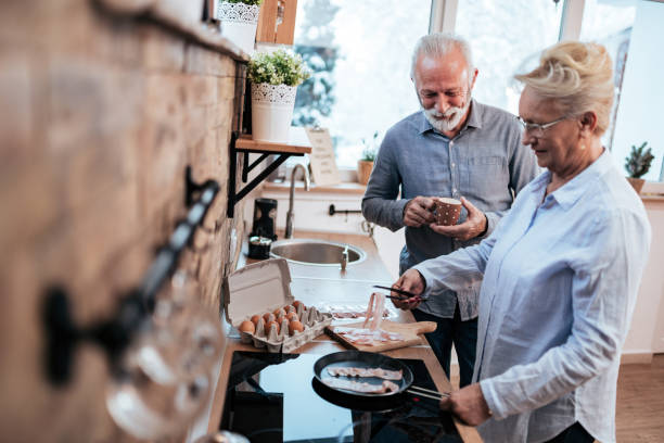 istock Senior couple standing in the kitchen at home, cooking breakfast and drinking coffee. 1094497704