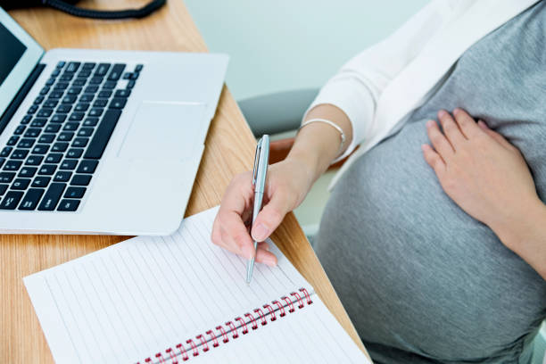 istock Pregnant woman writing in the office 1094518404