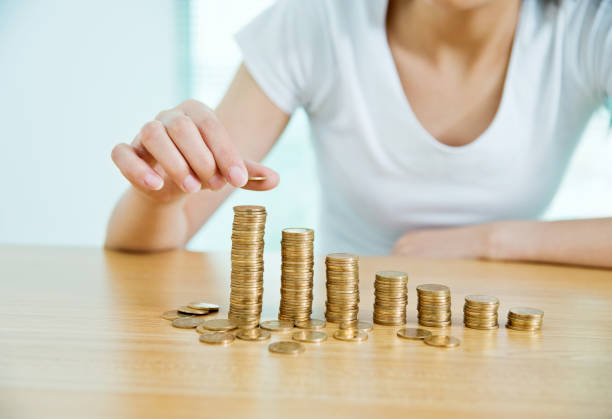 istock Woman putting a coin on stack of currency 1094521942